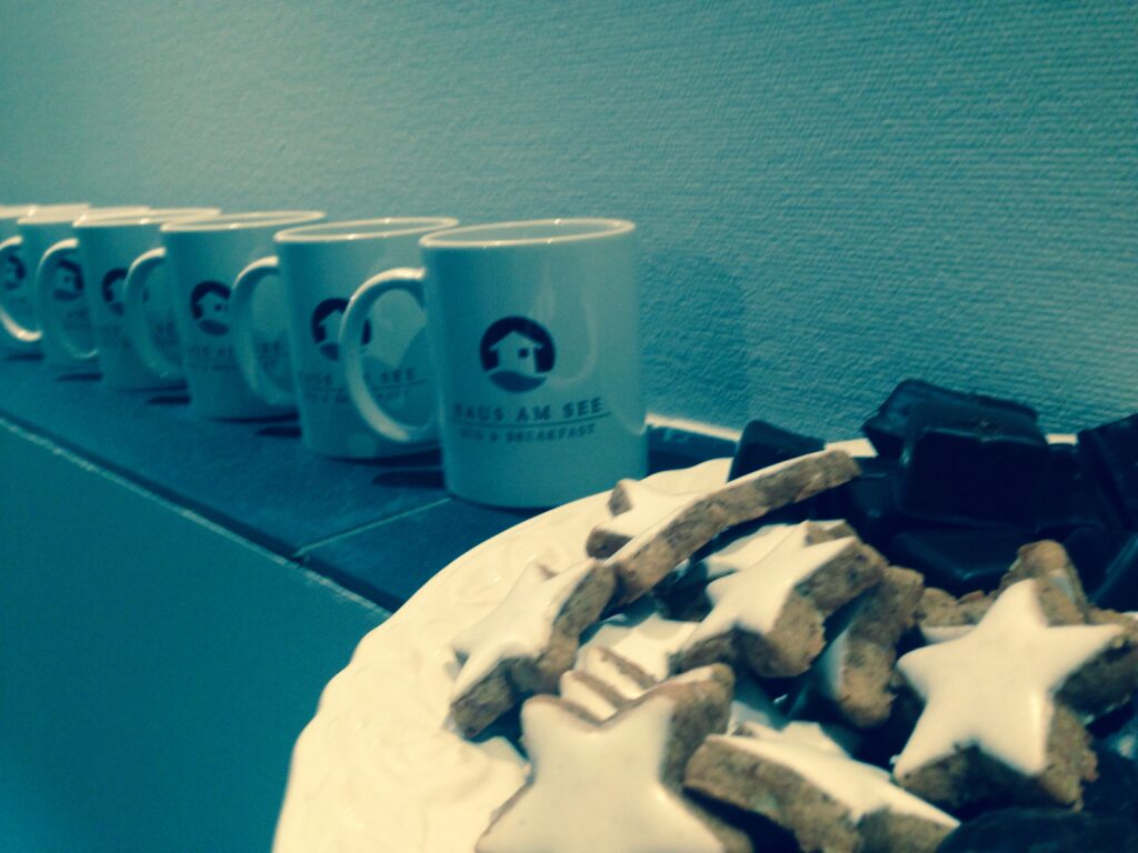 Kaffeetassen mit dem Logo des Haus am See und hölzerne Sterne