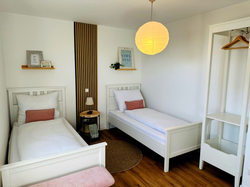Zweiter Schlafbereich im Appartement M mit zwei Einzelbetten und Kleiderstange
