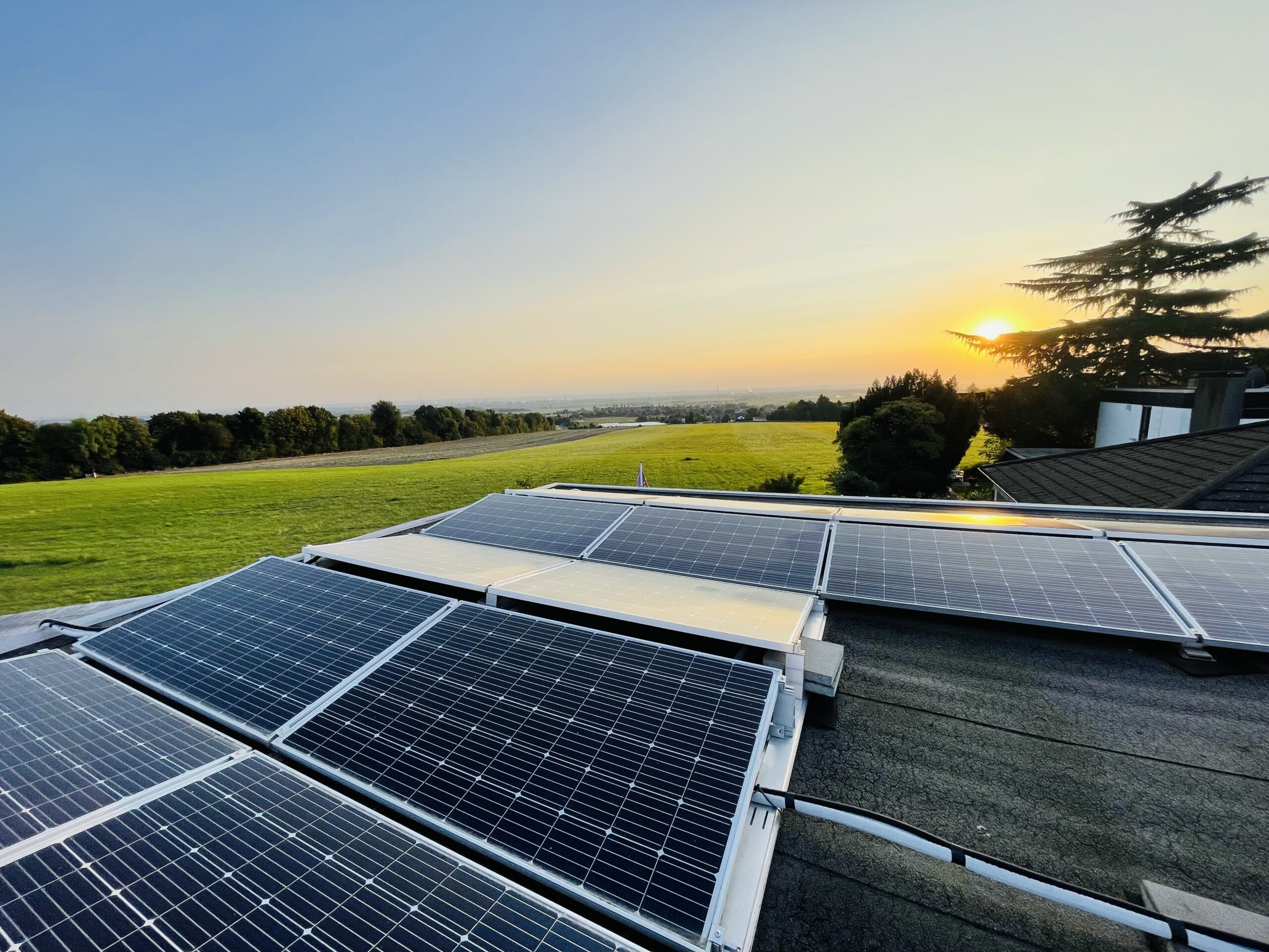 Photovoltaikanlage auf dem Dach des Haus am See B&B in Bornheim-Walberberg bei Sonnenuntergang, im Hintergrund die Felder der Ville