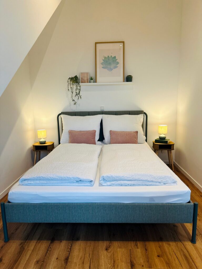 Schlafbereich im Appartement L mit Doppelbett unter der Dachschräge