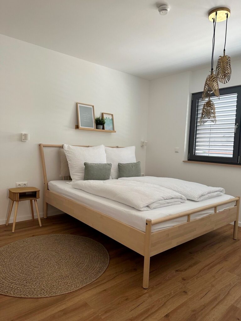 Schlafbereich im Appartement M mit Doppelbett und Hängeleuchte