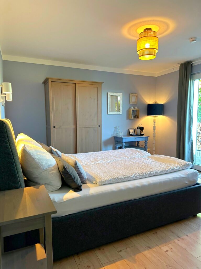 Doppelbett im Deluxe Zimmer Bleibtreusee mit Blick zur Terrasse