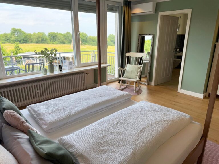Doppelbett im Deluxe Zimmer Donatussee vor der Fensterfront zur Rheinebene