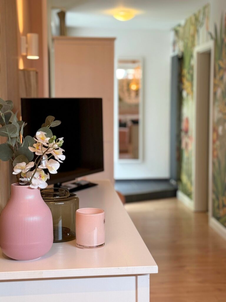 Kommode mit Fernseher und Blumen im Comfort Doppelzimmer Mondsee