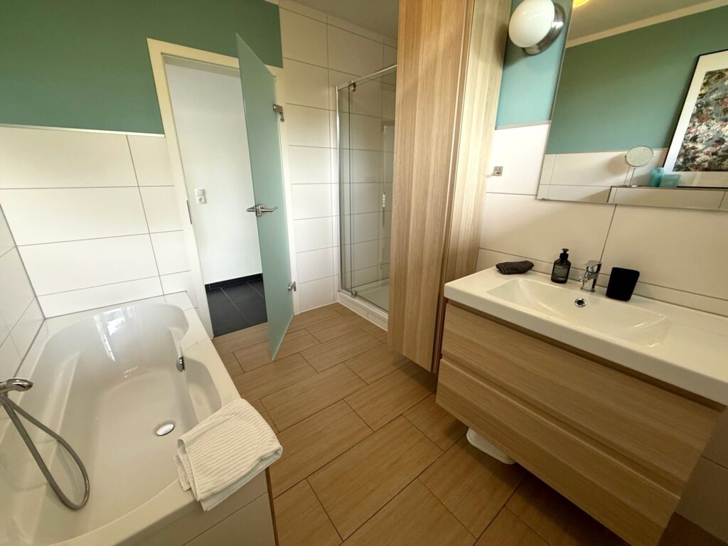 Bad der Familiensuite Zwillingssee mit Badewanne, Dusche und Waschtisch