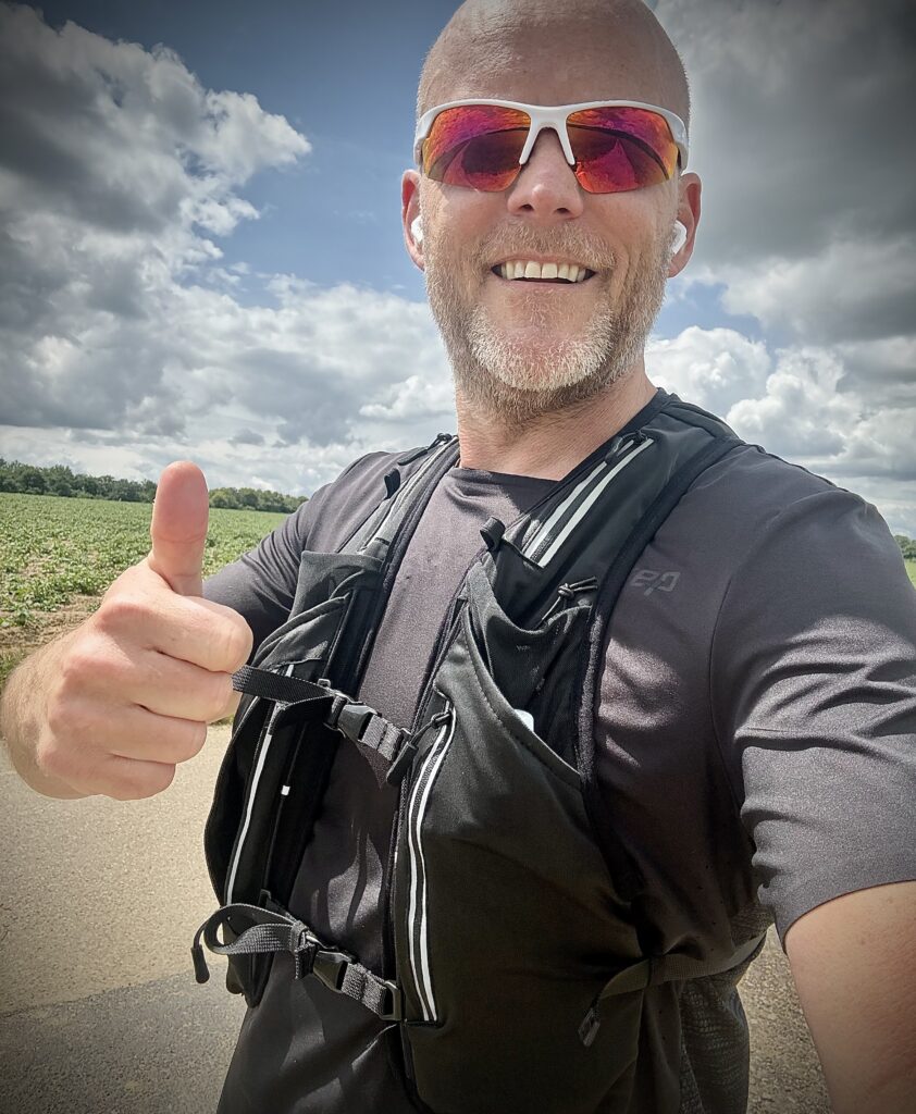 Läufer mit Laufweste und Sonnenbrille unterwegs in der Ville