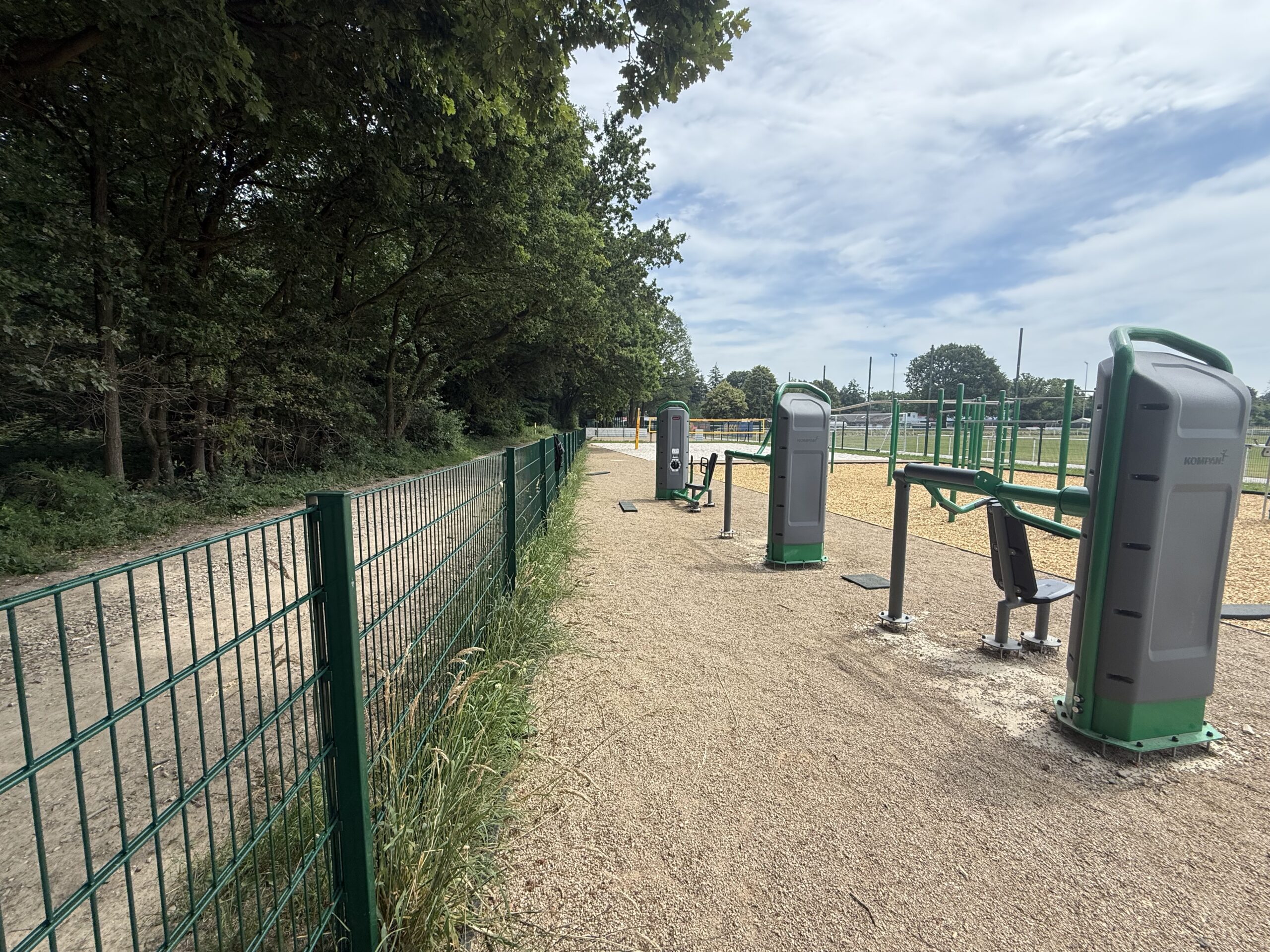 Outdoor-Fitnessgeräte am Sportplatz in Bornheim-Merten, daneben Bäume und Zaun
