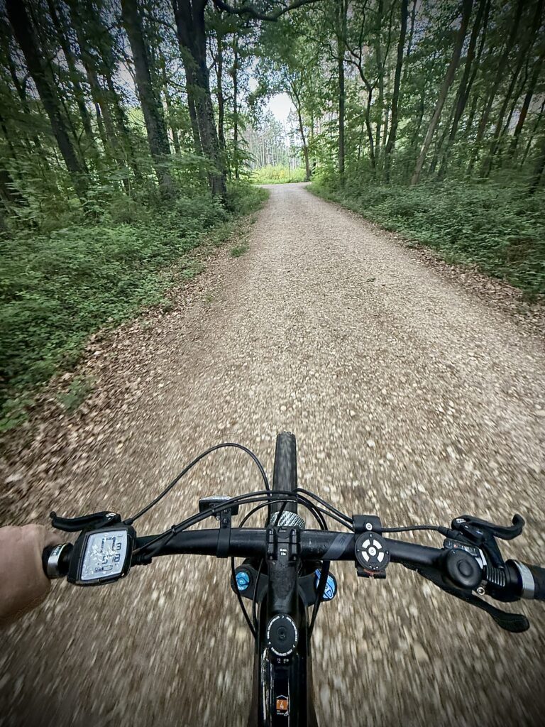 Mit dem Rad auf einem Schotterweg durch den Wald